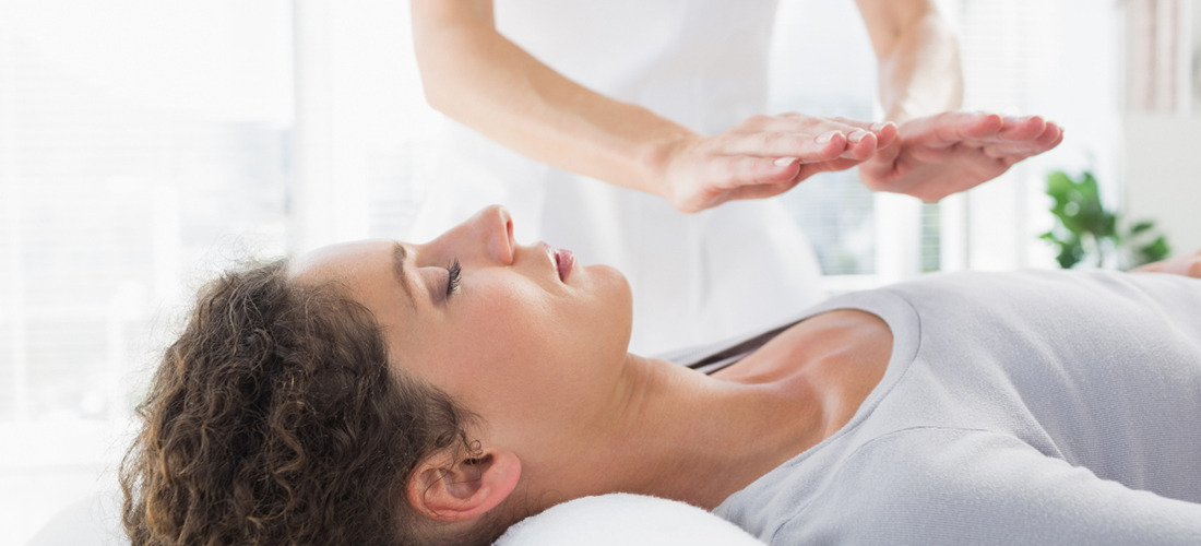 Mujer recibiendo terapia de masaje Reiki